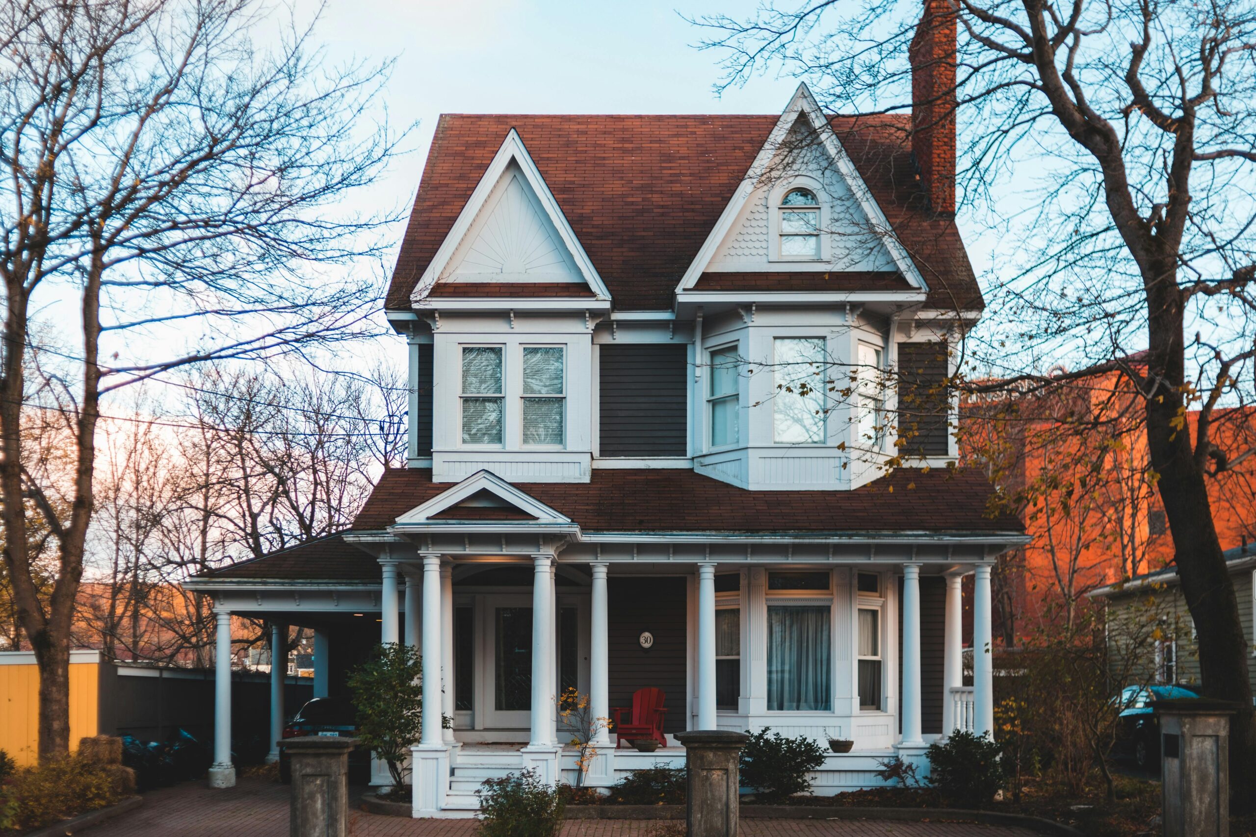 Elegant Victorian home exuding charm with its classic architectural features, set amid autumn foliage.